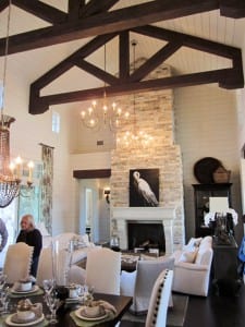 A two-story limestone fireplace and dark brown trusses set the stage for this Southern Living Showcase Home near Austin, Texas.