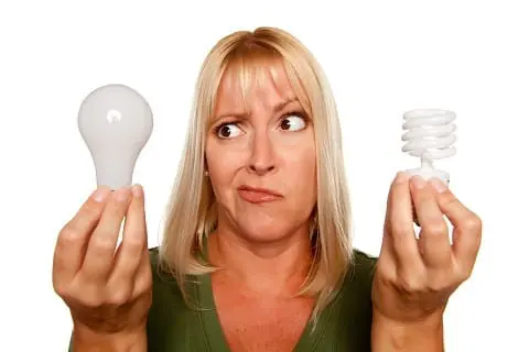 Woman with an incandescent bulb and a squiggly, or CFL, bulb.