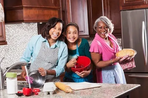 Three generations of women baking in their new home.