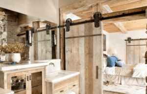wood barn door separating bathroom from master bedroom