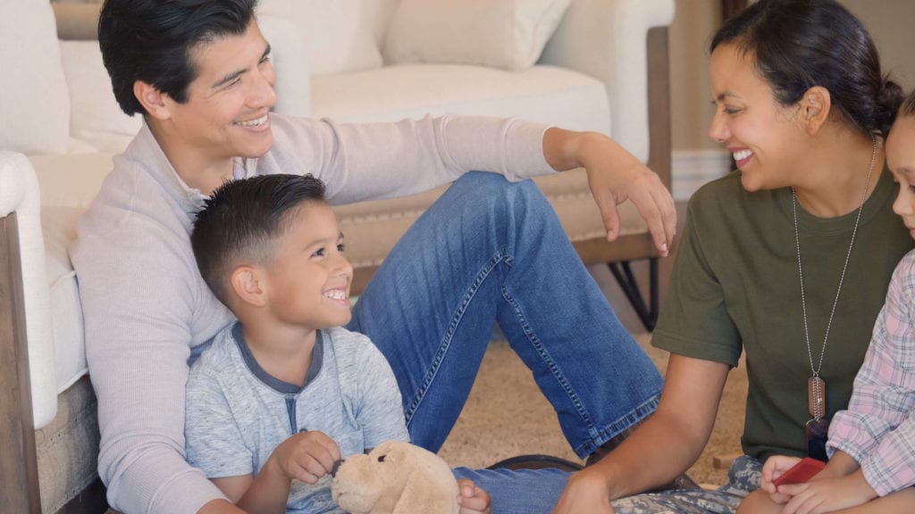 Family sits with mom, who is a veteran and wearing her uniform