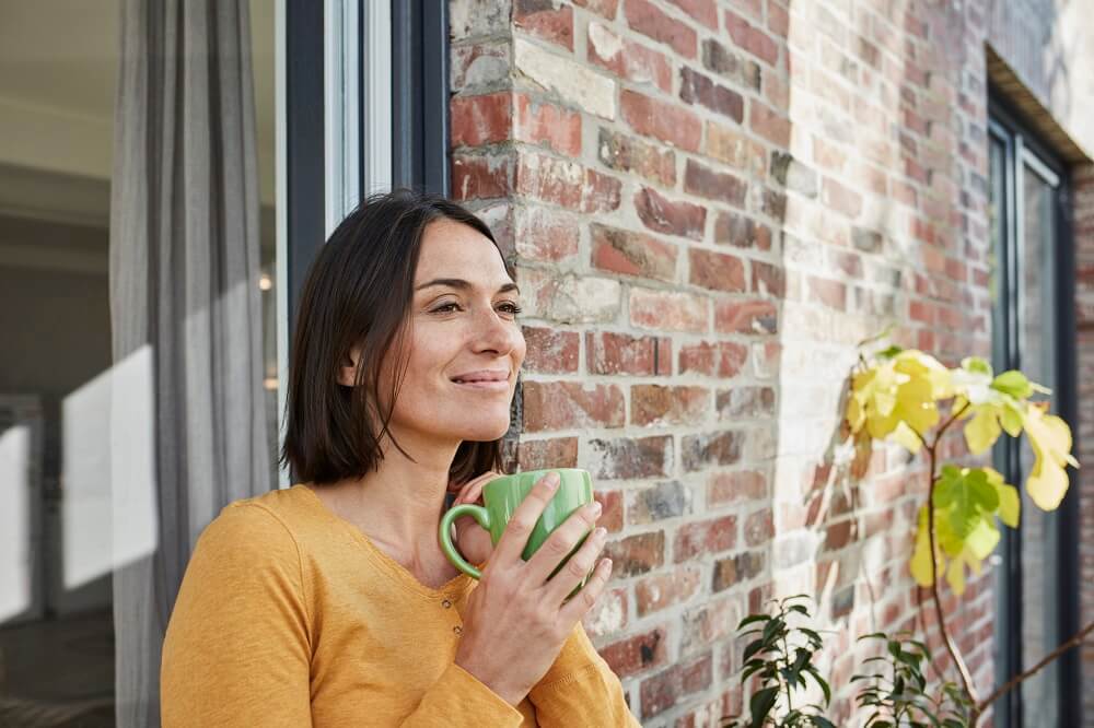 Woman standing on patio with mug
