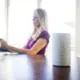 Woman sitting at desk with a smart home hub in focus on the table.