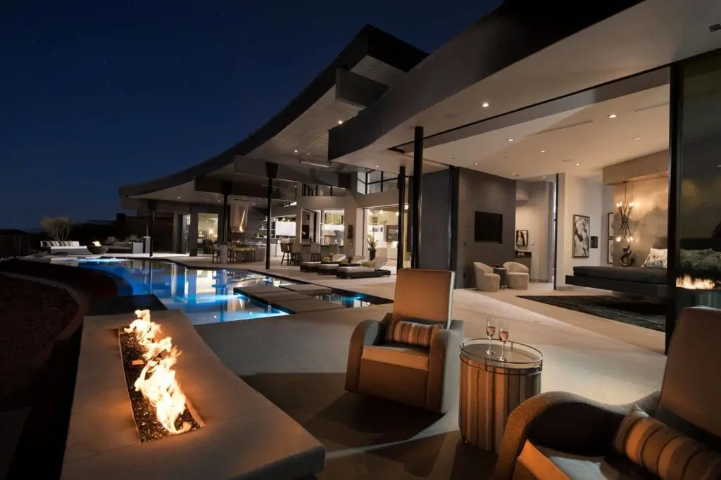 Indoor/outdoor living with an outdoor fireplace, pool and nice seating