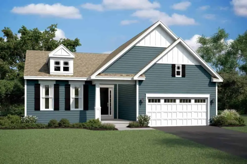 Charming craftsman style home with grey siding, a port style window, and stone detailing.