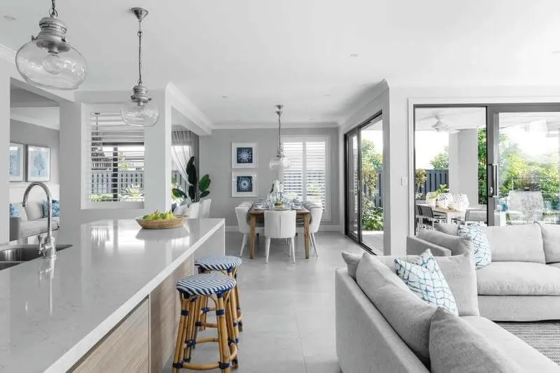 Bright living room and kitchen area with patio designed with white walls and furniture