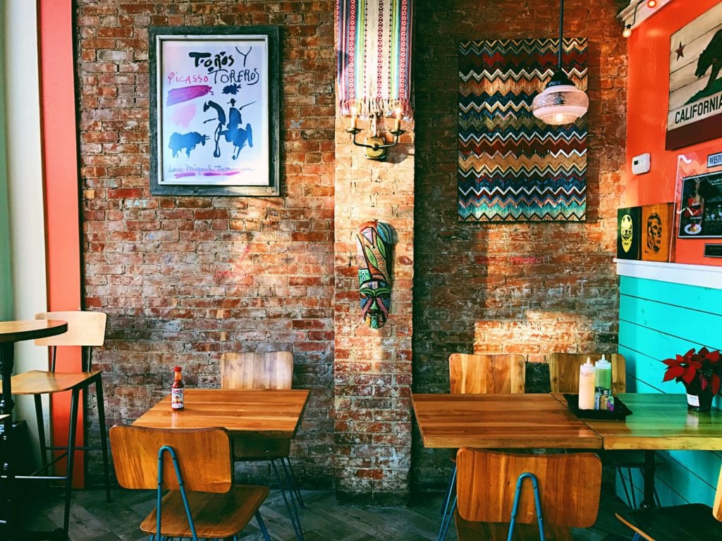 Bohemian gallery wall in front of a brick facade