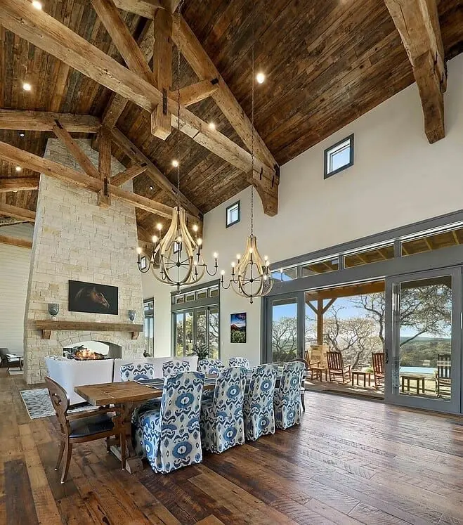 Ranch-style great room with vaulted ceiling made of natural wood and a floor-to-ceiling stone fireplace