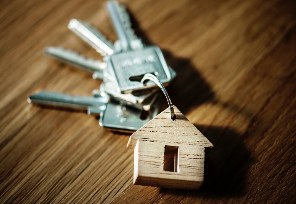 Set of keys with house keychain on wooden desk