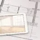Tablet showing home rendering lying on top of a drawn floor plan