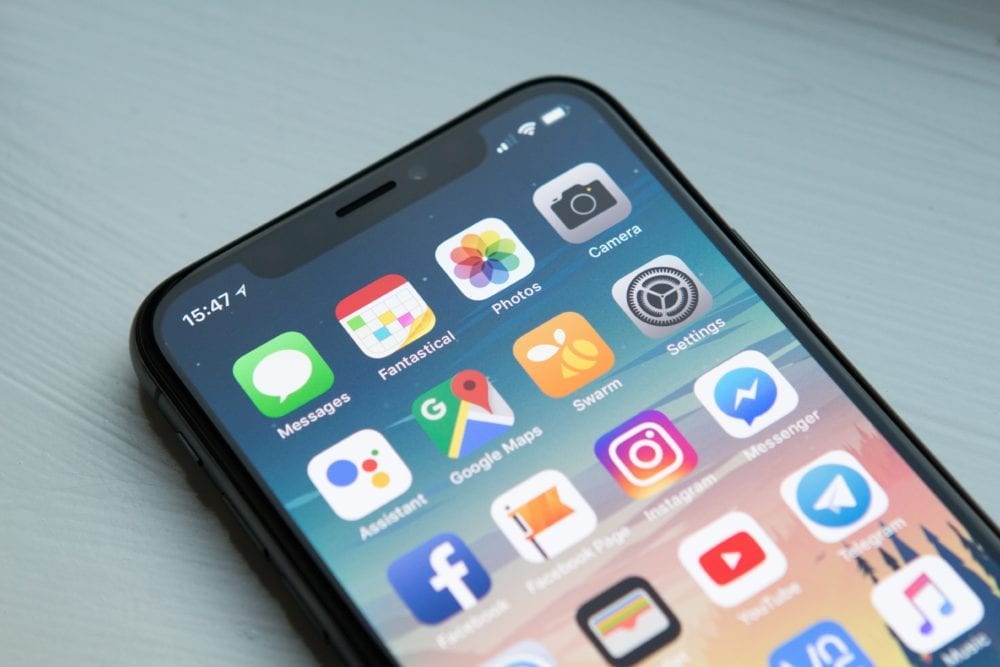 space gray iPhone X with apps on screen