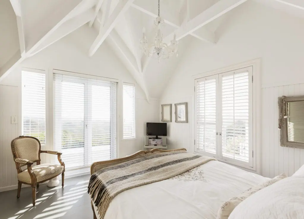 Modern, white luxury bedroom with vaulted ceilings, which add more light to the space. 