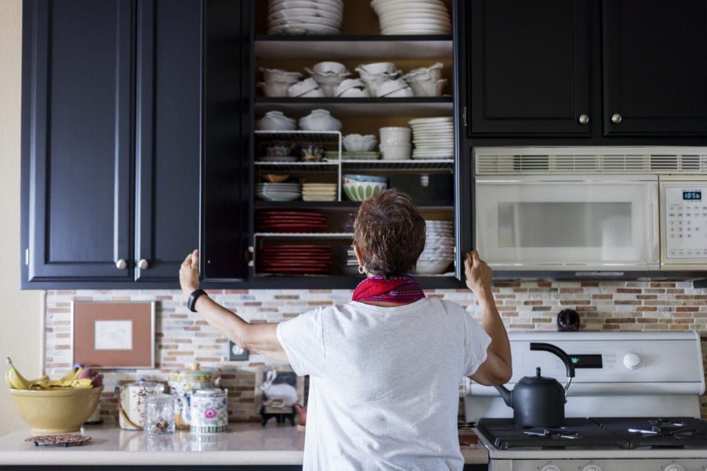 Woman checking tall cabinet in her kitchen