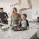Family baking muffins in the kitchen of a new home on a granite countertop