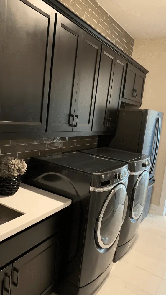 A laundry room featuring an extra fridge and sink.