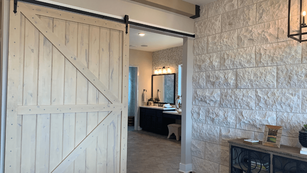 A barn door separates rooms in a model home.