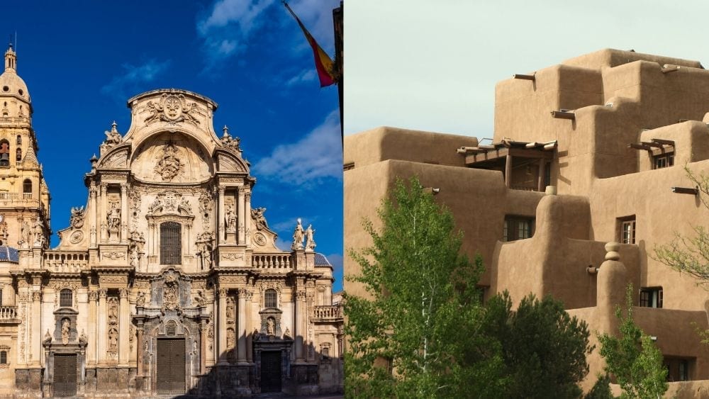 The left-hand side of the image is a stone church carved with intricate designs and flourishes that make it seem larger-than-life. On the righthand side of the image is a light brown, multitiered adobe building with exposed wooden beams and inset windows and doors.