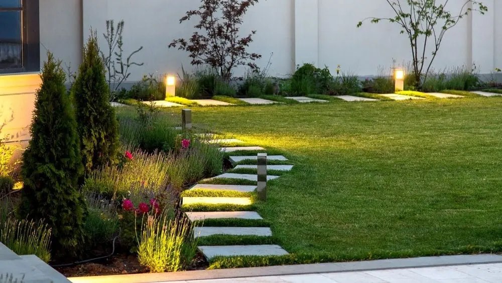Moved backyard with landscaping along the edge of the house and pavers around the edge, creating a curved path.