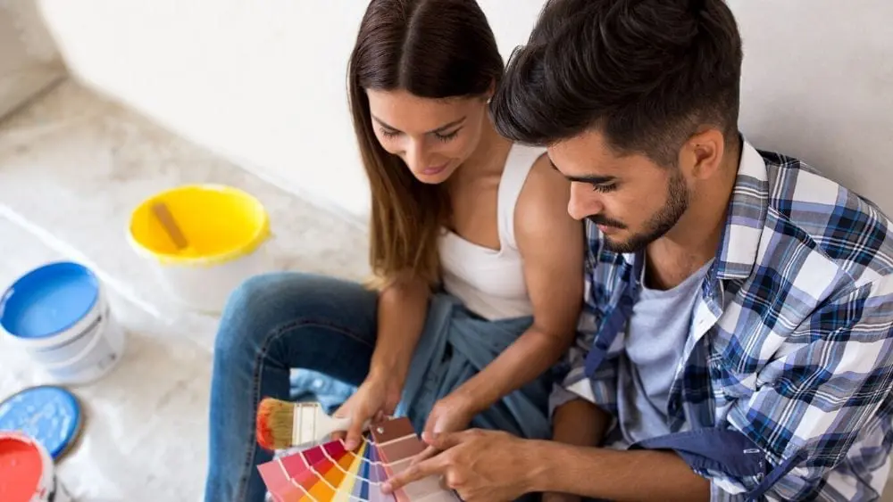 young couple painting a house