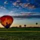 Hot air balloon rise in an Iowa field with a sunrise in background