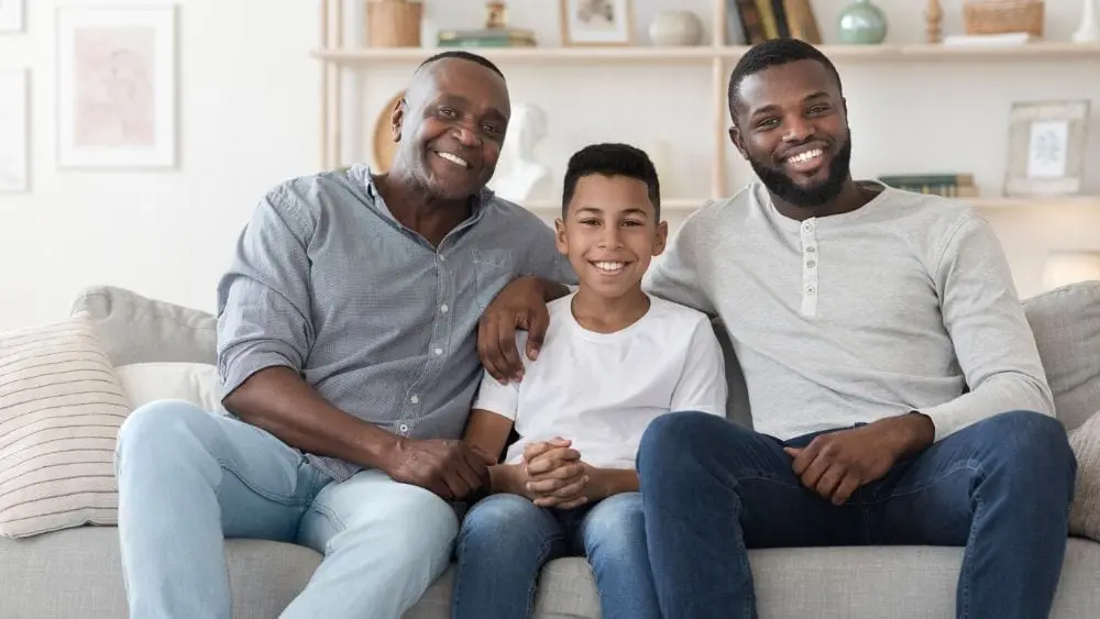 Father, son, grandfather sitting in a multigenerational living room.