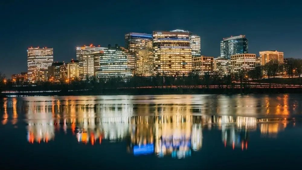 Nighttime view of the Arlington skyline reflected on the water.