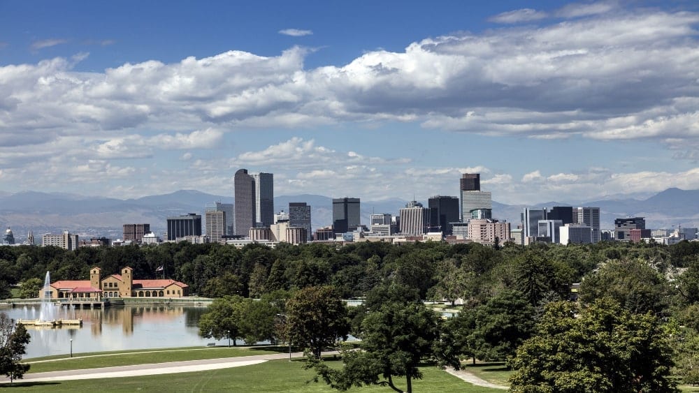 View of daytime skyline of Denver with Rocky Mountains in the background