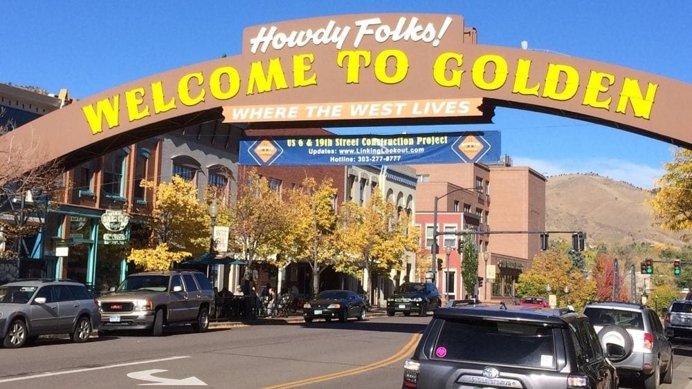 A town square with an archway over the street that reads "Howdy Y'all! Welcome to Golden."