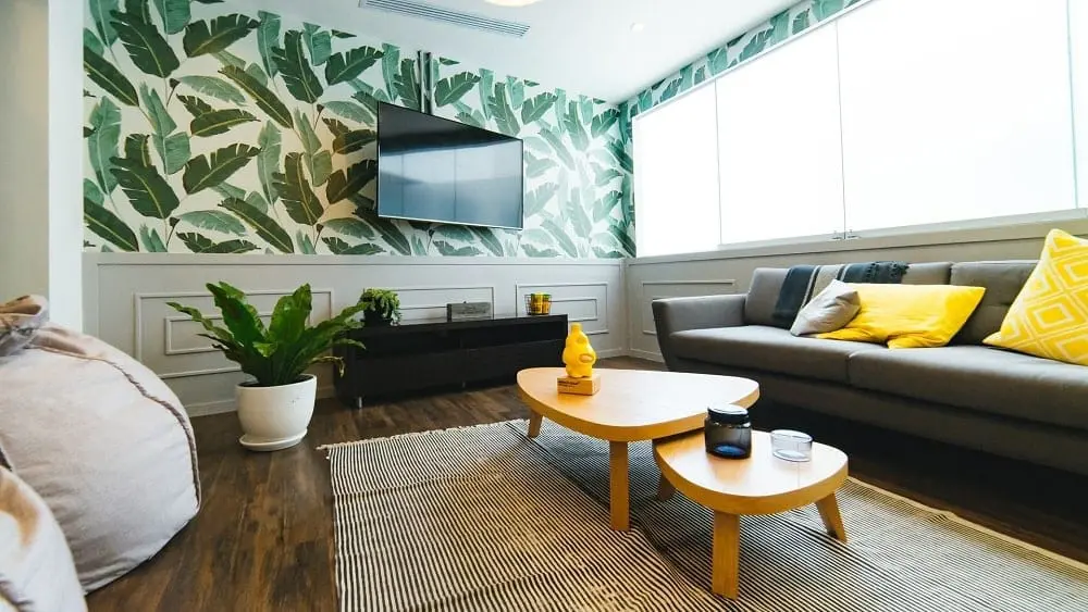 Comfy living room with banana leaf wallpaper.