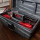 Black toolbox that is opened to show red and black tools inside.
