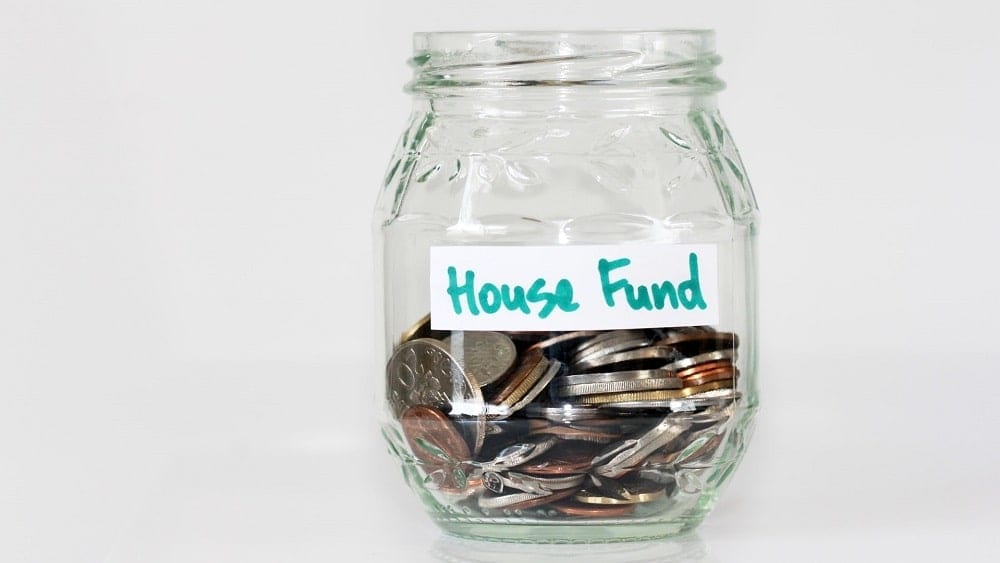 A jar of coins with a label that reads "House Fund".