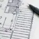 Close shot of floor plan with a pen and ruler on top.