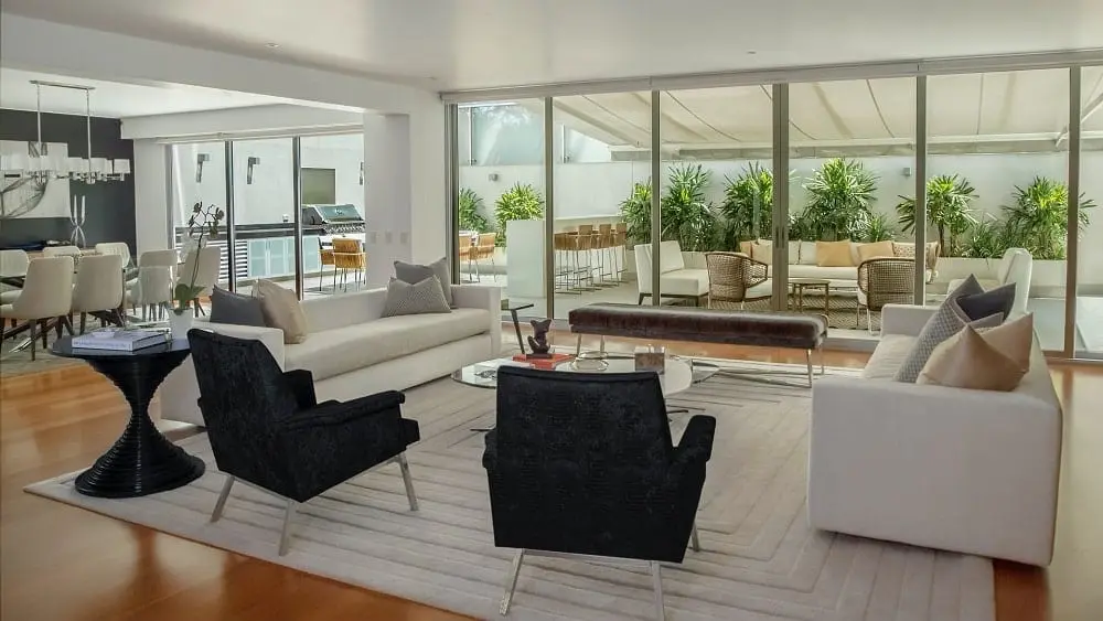 Open plan living room with dining room and outdoor living area in the background.