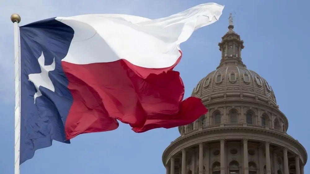 The Texas flag waving in front of the state capital.