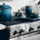 Kitchen with silver oven and blue cooking accessories.