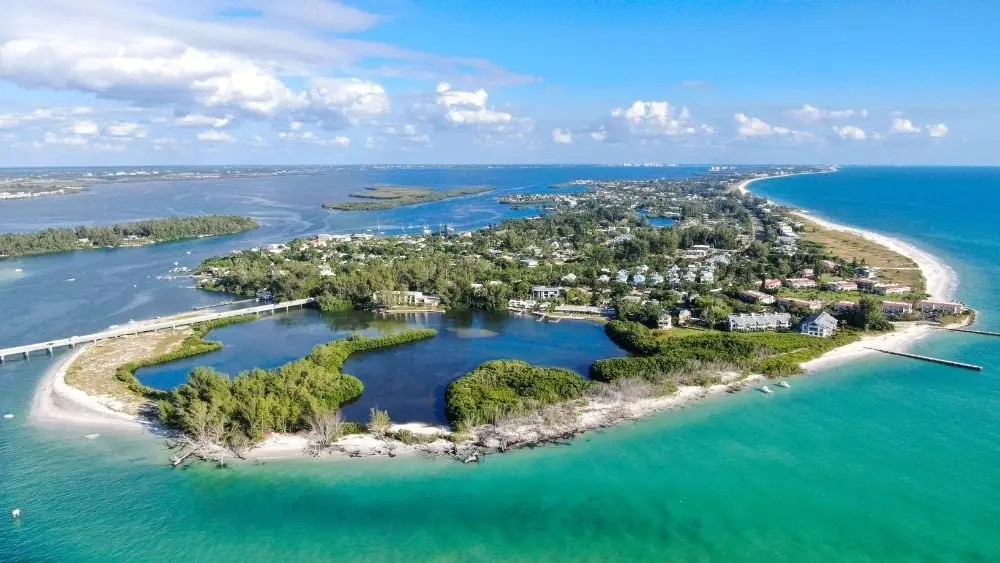 Aerial view of Longboat Key, an island off the coast of Florida with lots of trees and a few lakes.