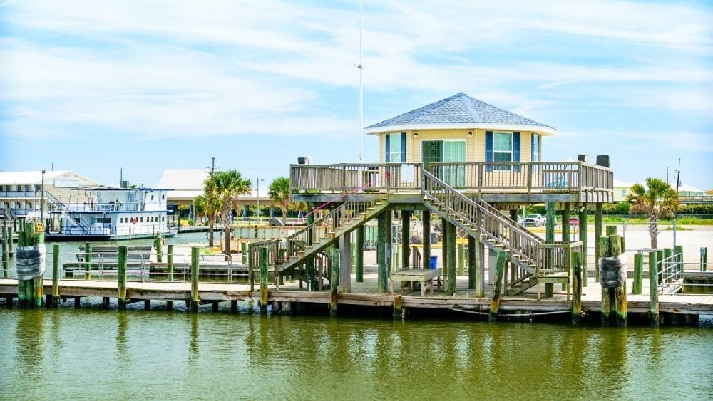 A house on the water with a pier surrounding it.