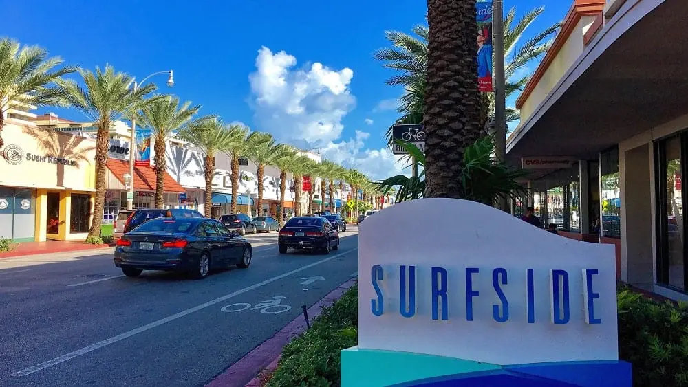 A shopping street and welcome sign for Surfside, FL.