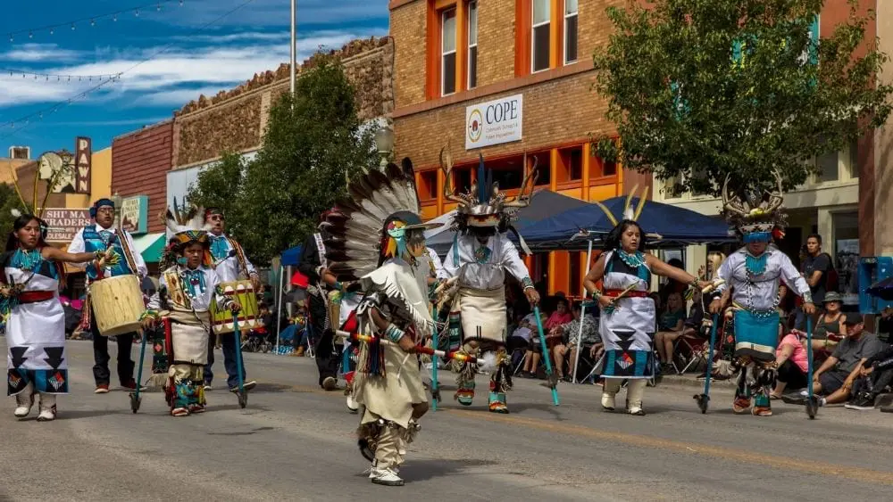 Indigenous folks marching in a parade celebrating Native culture.