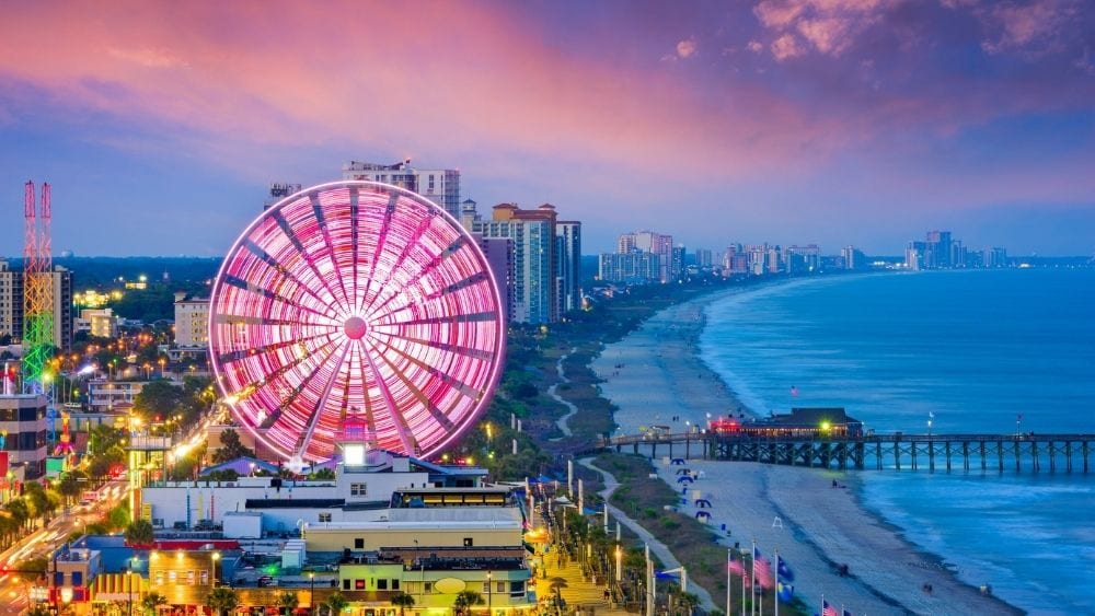 A time-lapse photo showing Myrtle Beach attractions lit up at sunset.