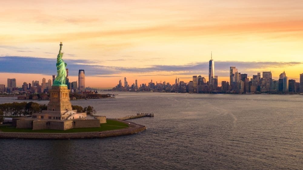 New York City skyline and the Statue of Liberty at sunset.
