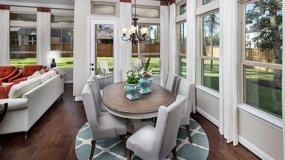 Luxury dining space with bay windows, a round table, and a chandelier.
