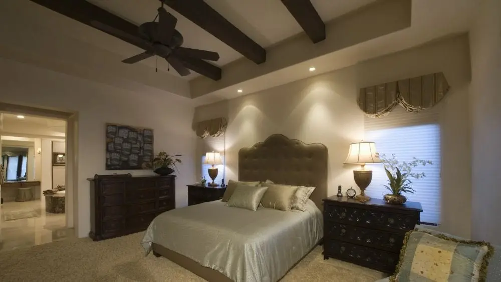 A large bedroom with a beamed ceiling.