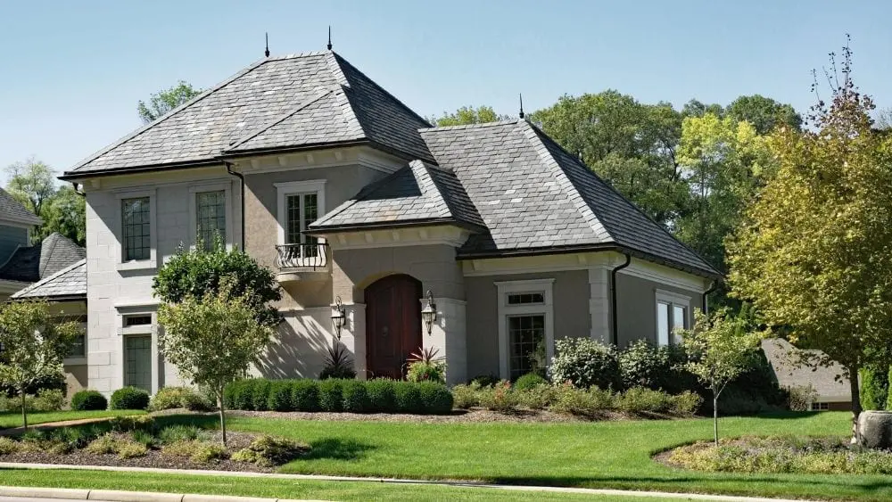 A large house made of brick and stucco with a grey slate roof.