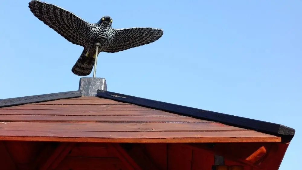 A synthetic wood roof with a dummy hawk at the top.