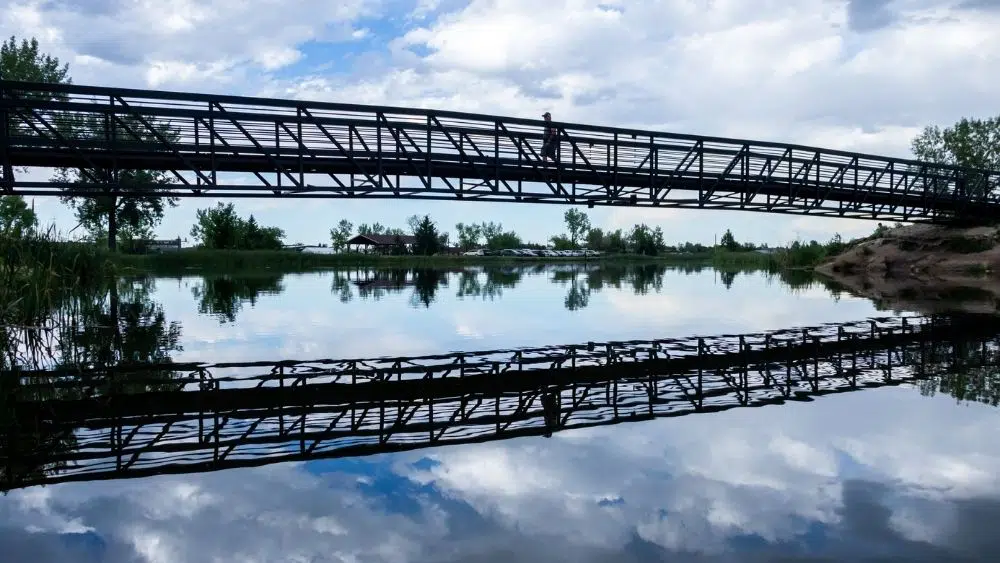 Metal bridge near Gillette, Wyoming that reflects clearly on the water.
