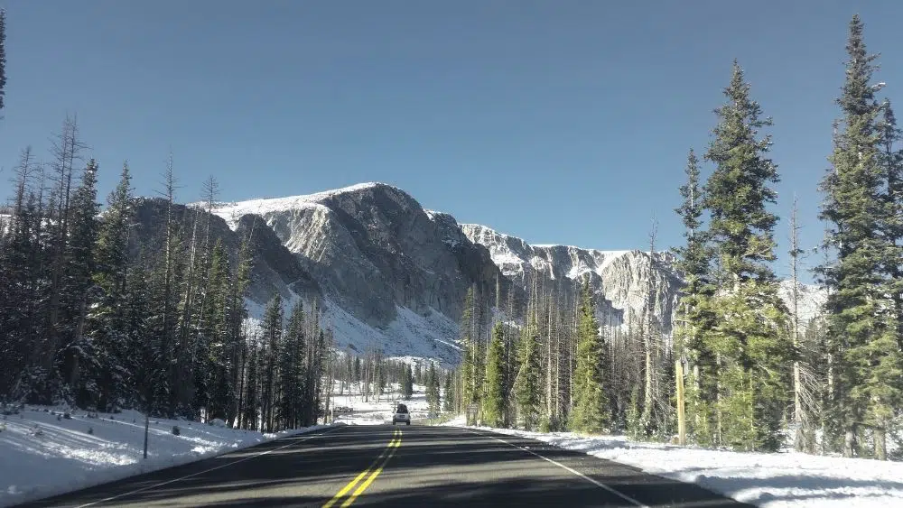 Road leading to snow-capped mountains near Laramie, Wyoming.