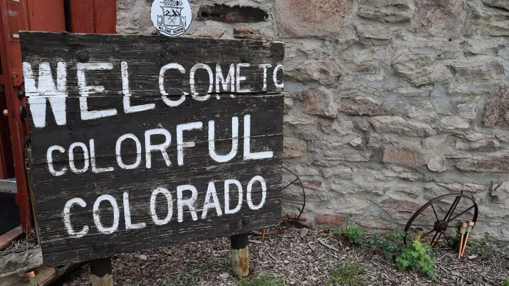 Wooden sign that reads "Welcome to Colorful Colorado."