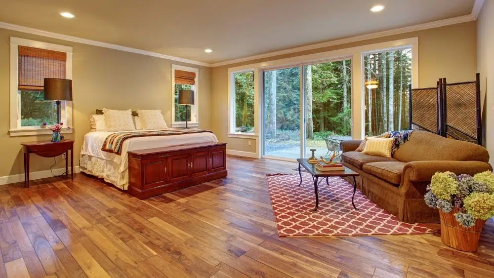 Large bedroom with double doors leading into a forest area.