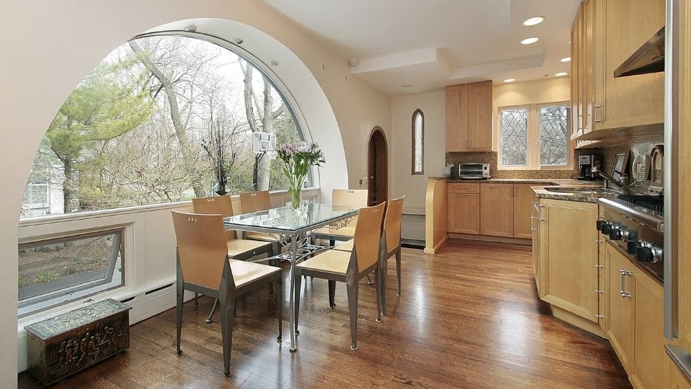 A kitchen with a large arched window.